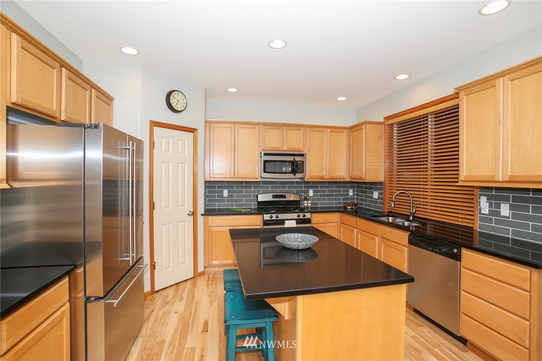 813 Field Avenue Northeast Renton, WA 98059 - Photo 9 of 22 a kitchen with stainless steel appliances granite countertop a sink a stove and a refrigerator
