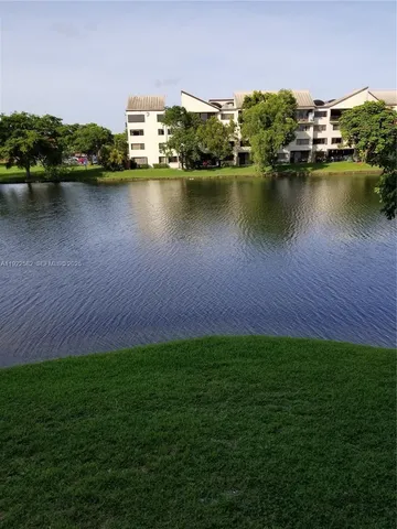 an aerial view of residential houses with outdoor space and lake view