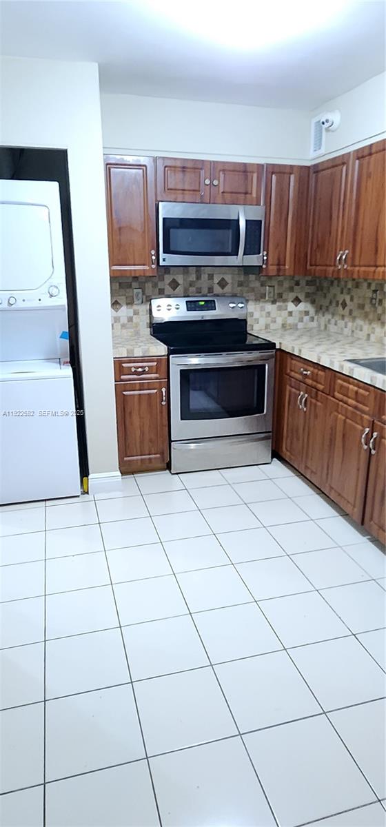 6701 Southwest 116th Court, Unit 203 Miami, FL 33173 - Photo 11 of 12 a kitchen with granite countertop a stove a sink and a microwave