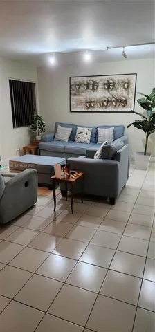a living room with furniture a rug and white walls