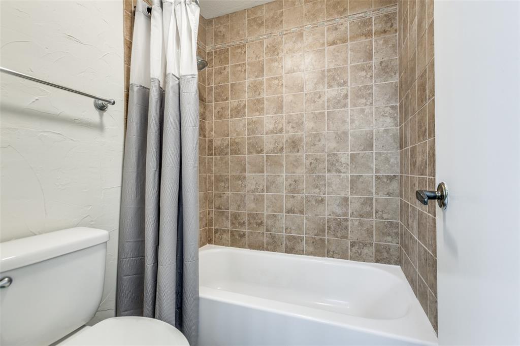 6122 Ridgecrest Road, Unit 2007 Dallas, TX 75231 - Photo 12 of 13 Full bathroom with shower / tub combo and a textured wall
