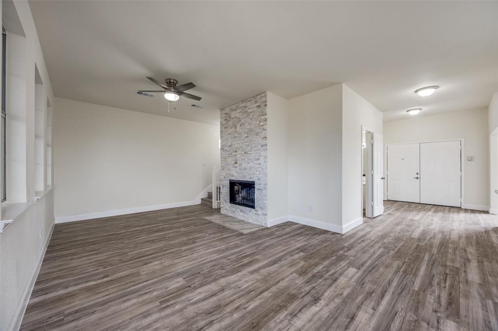 471 Meadowview Circle Van Alstyne, TX 75495 - Photo 12 of 39 wooden floor in an empty room with a fireplace