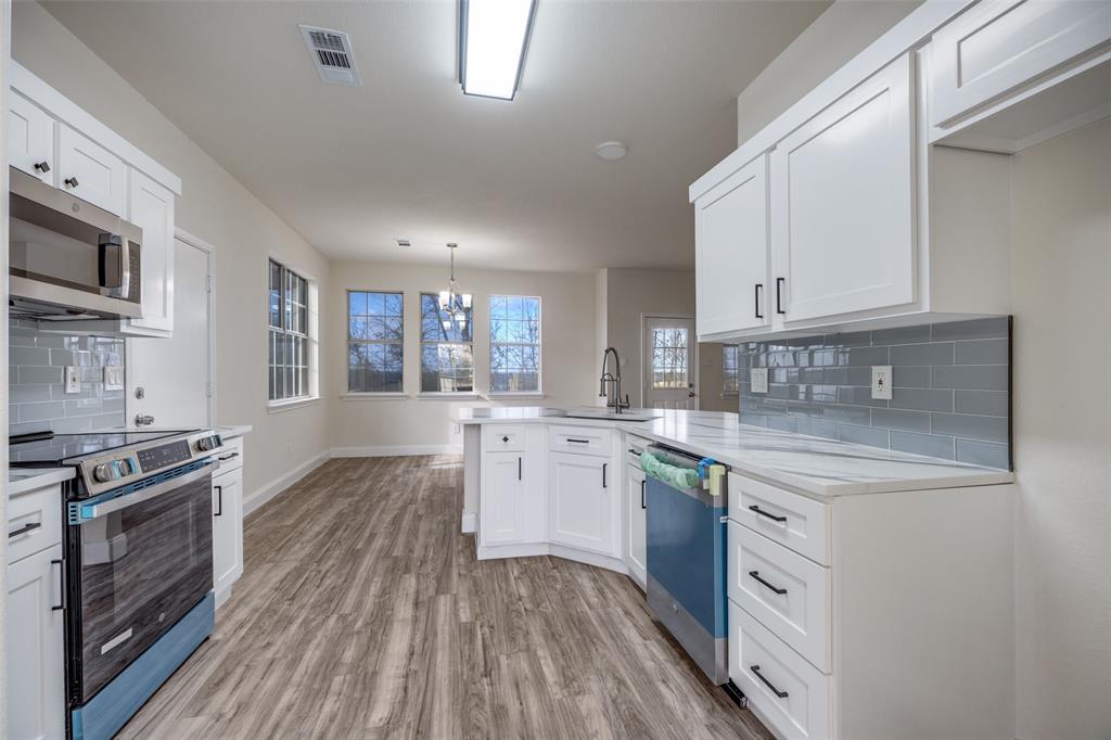471 Meadowview Circle Van Alstyne, TX 75495 - Photo 8 of 39 a kitchen with a stove a sink and wooden floor