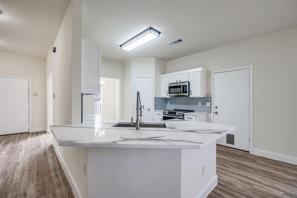 471 Meadowview Circle Van Alstyne, TX 75495 - Photo 9 of 39 a kitchen with stainless steel appliances granite countertop a sink stove and microwave