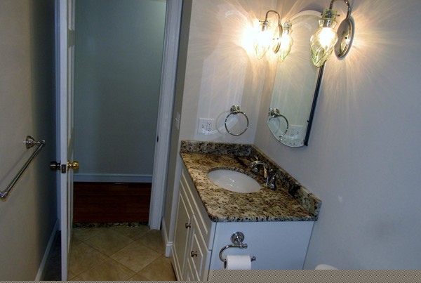 1247 Trapelo Road Waltham, MA 02451 - Photo 11 of 28 a bathroom with a granite countertop sink and a mirror
