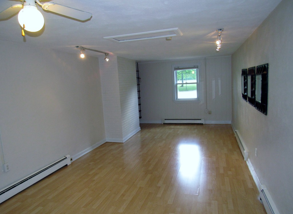 1247 Trapelo Road Waltham, MA 02451 - Photo 12 of 28 an empty room with wooden floor and windows