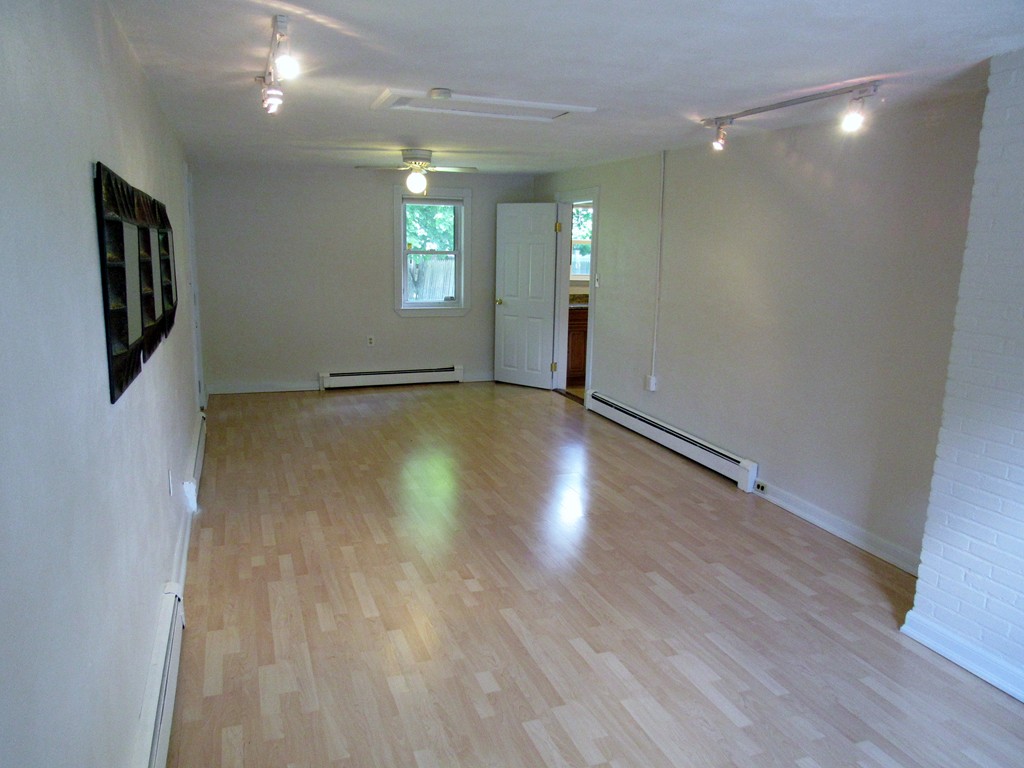 1247 Trapelo Road Waltham, MA 02451 - Photo 13 of 28 an empty room with wooden floor and windows