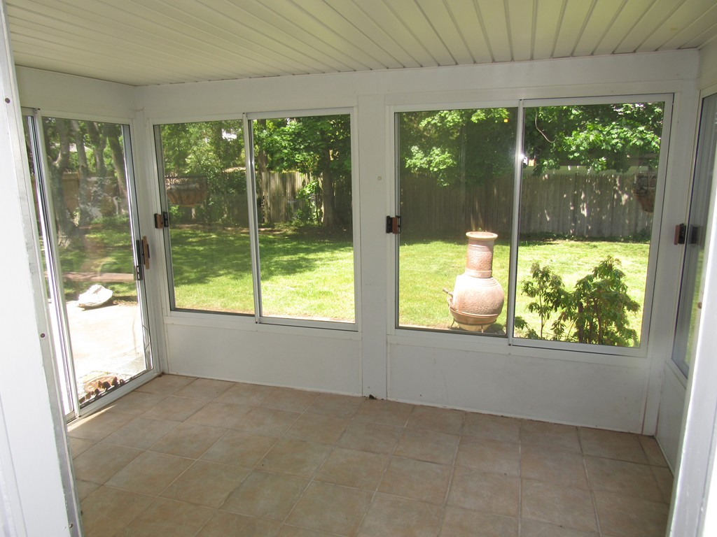 1247 Trapelo Road Waltham, MA 02451 - Photo 28 of 28 a view of an empty room with wooden floor and a floor to ceiling window
