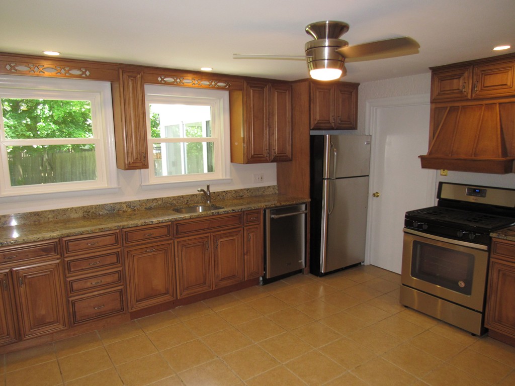 1247 Trapelo Road Waltham, MA 02451 - Photo 7 of 28 a kitchen with stainless steel appliances granite countertop a stove a sink and a refrigerator
