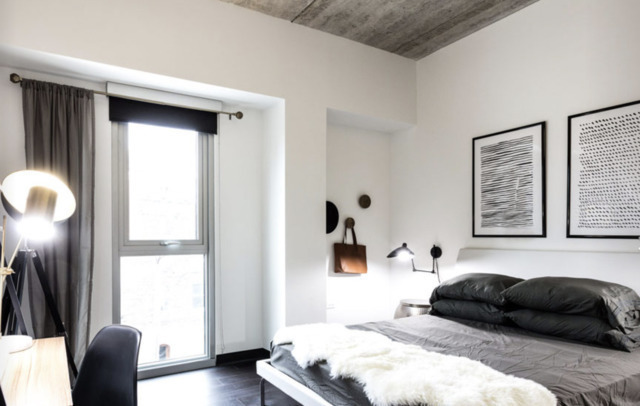 710 West Grand Avenue, Unit 412 Chicago, IL 60654 - Photo 3 of 5 a bedroom with a bed and a large mirror