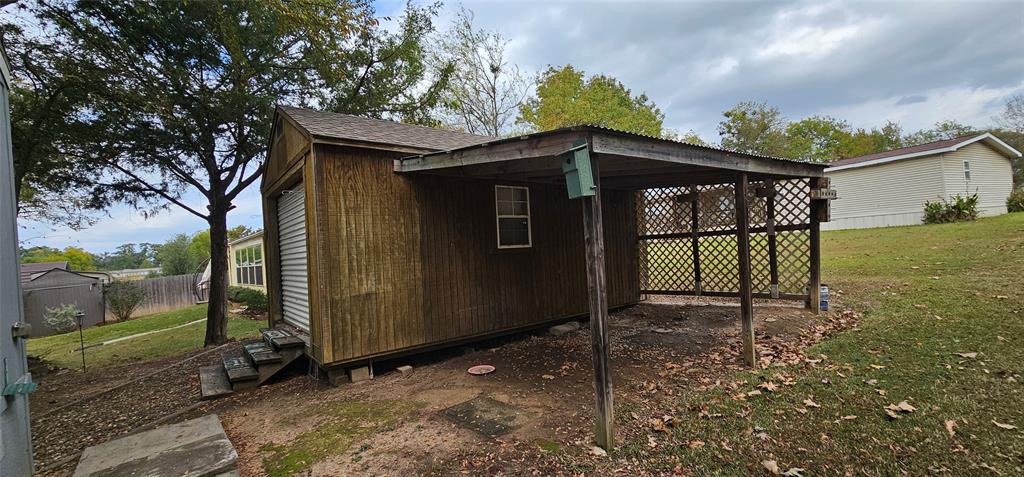 434 Geronimo Quitman, TX 75783 - Photo 8 of 36 a view of a wooden house with a large window and a yard
