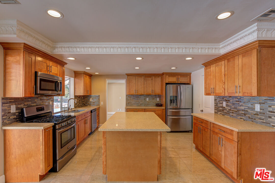 4041 Alonzo Avenue Encino, CA 91316 - Photo 15 of 41 a large kitchen with stainless steel appliances kitchen island granite countertop a large counter top cabinets and a sink