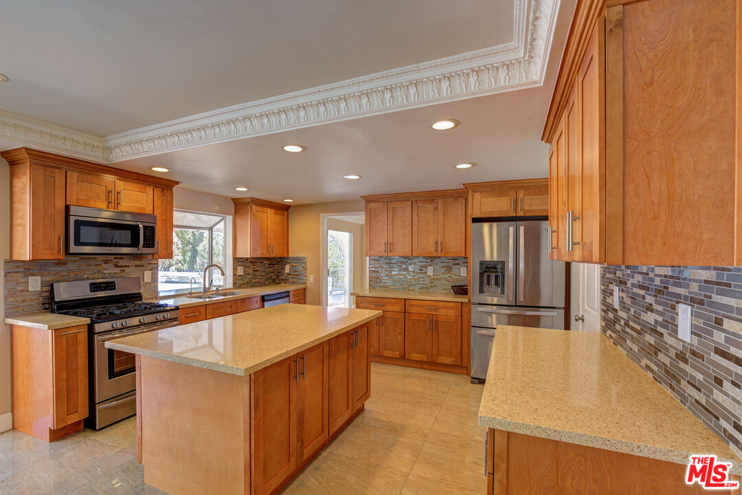 4041 Alonzo Avenue Encino, CA 91316 - Photo 17 of 41 a kitchen with stainless steel appliances granite countertop a sink a stove and a refrigerator