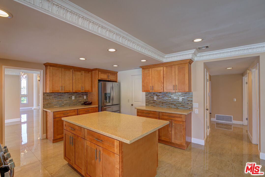 4041 Alonzo Avenue Encino, CA 91316 - Photo 19 of 41 a kitchen with a stove a refrigerator a sink a dining table and chairs