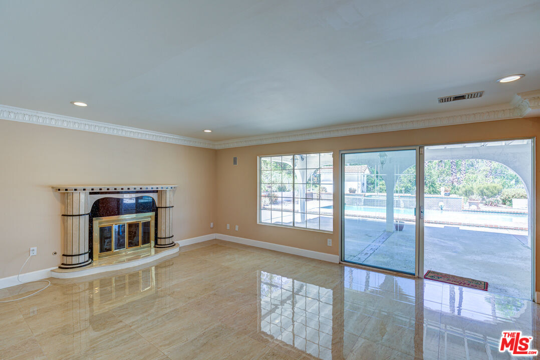 4041 Alonzo Avenue Encino, CA 91316 - Photo 6 of 41 a living room with a fireplace and a large window