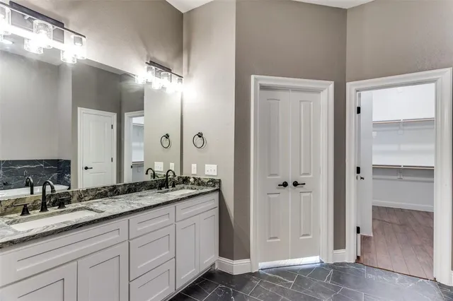 a bathroom with a double vanity sink and a mirror