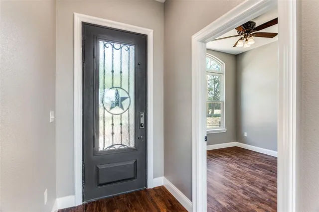 a view of a hallway with wooden floor and a dining room