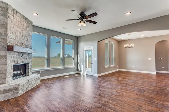 a view of an empty room with a fireplace and a window