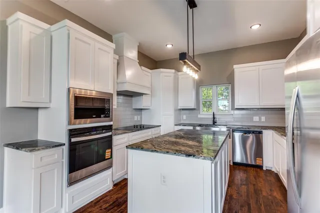 a kitchen with granite countertop a stove and a sink