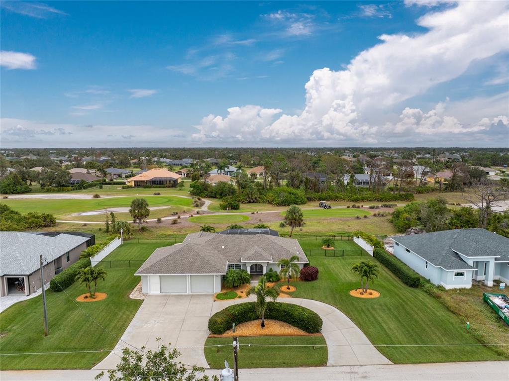 78 Fairway Road Rotonda West, FL 33947 - Photo 1 of 1 3/2 with 3 car garage screened on double door side, home situated on two lots, fenced in backyard on Pinemoor Golf Course Green of number 3 to the left and Tee Box of number 4 middle to right...