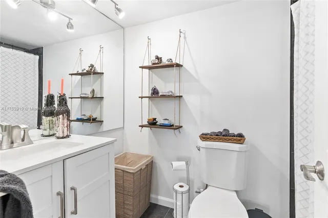 a bathroom with a sink a toilet and a mirror