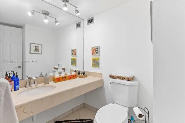 a bathroom with a sink vanity mirror and toilet