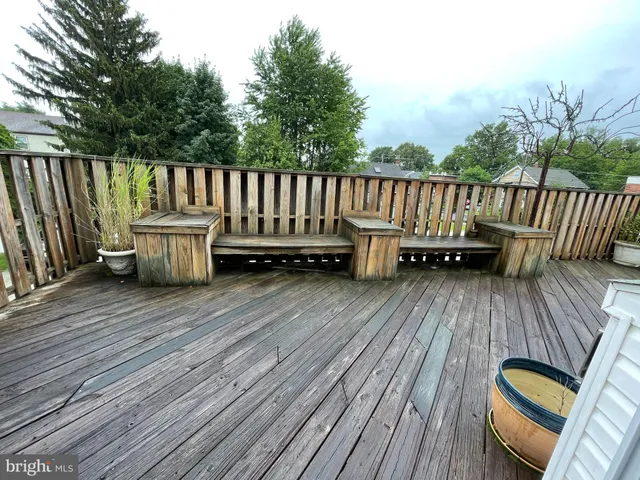 a view of a deck with wooden floor and fence with a barbeque