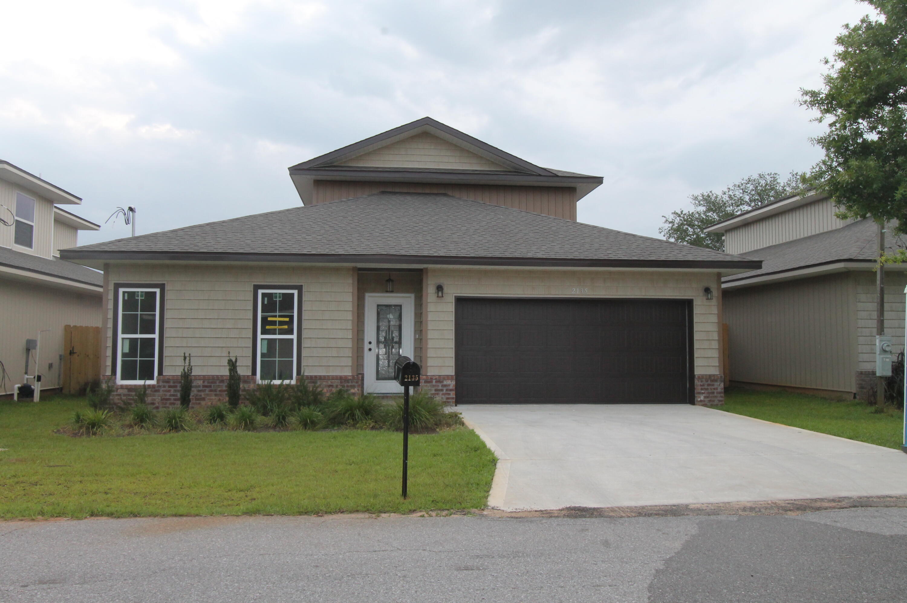 2135 Nina Street Navarre, FL 32566 - Photo 1 of 7 a front view of a house with a yard and garage
