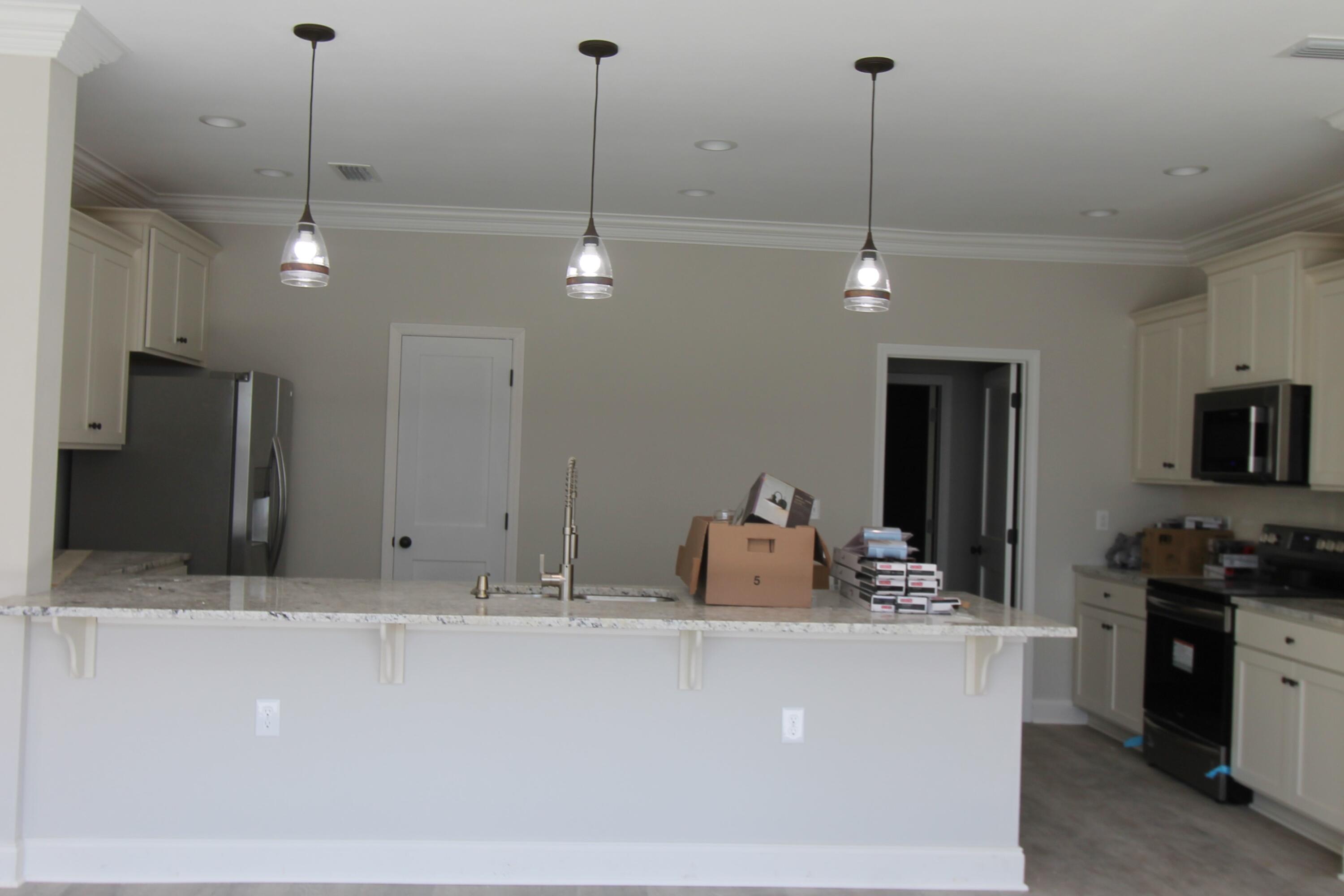 2135 Nina Street Navarre, FL 32566 - Photo 3 of 7 a kitchen with kitchen island a counter top space appliances and a ceiling fan