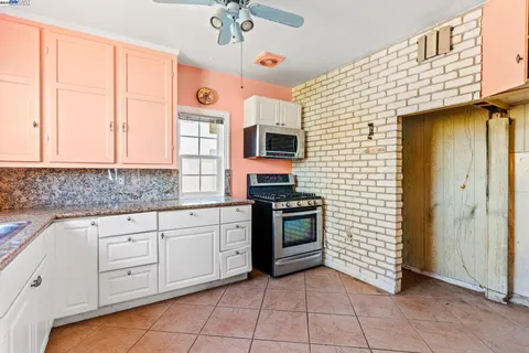 a kitchen with granite countertop a stove sink and cabinets