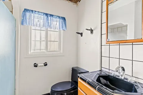 a bathroom with a sink a toilet and a mirror