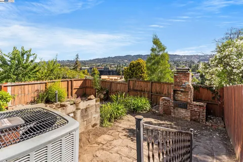 a view of a roof deck with couches and wooden fence