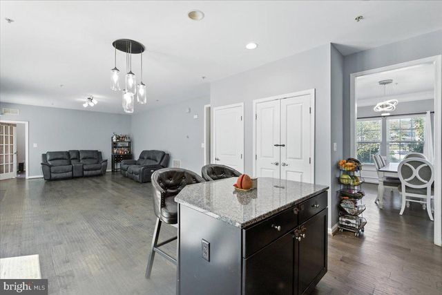 a living room with stainless steel appliances furniture a fireplace and a flat screen tv