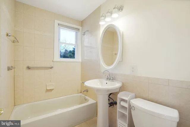 a bathroom with a sink mirror toilet and bathtub