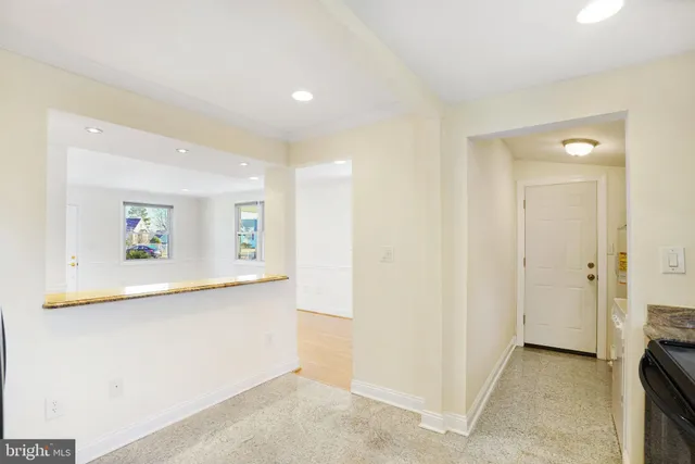 a view of a hallway with wooden floor and a living room