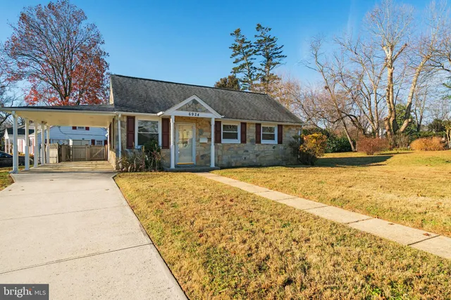 a front view of house with yard and trees around