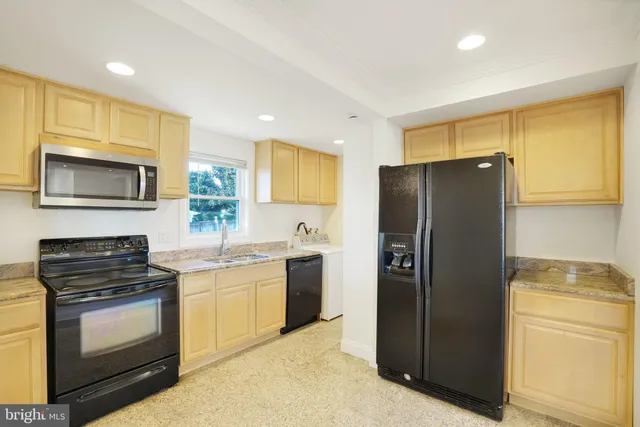 a kitchen with a refrigerator sink and stove top oven