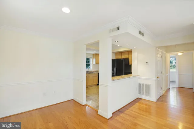 a view of a big room with wooden floor and windows