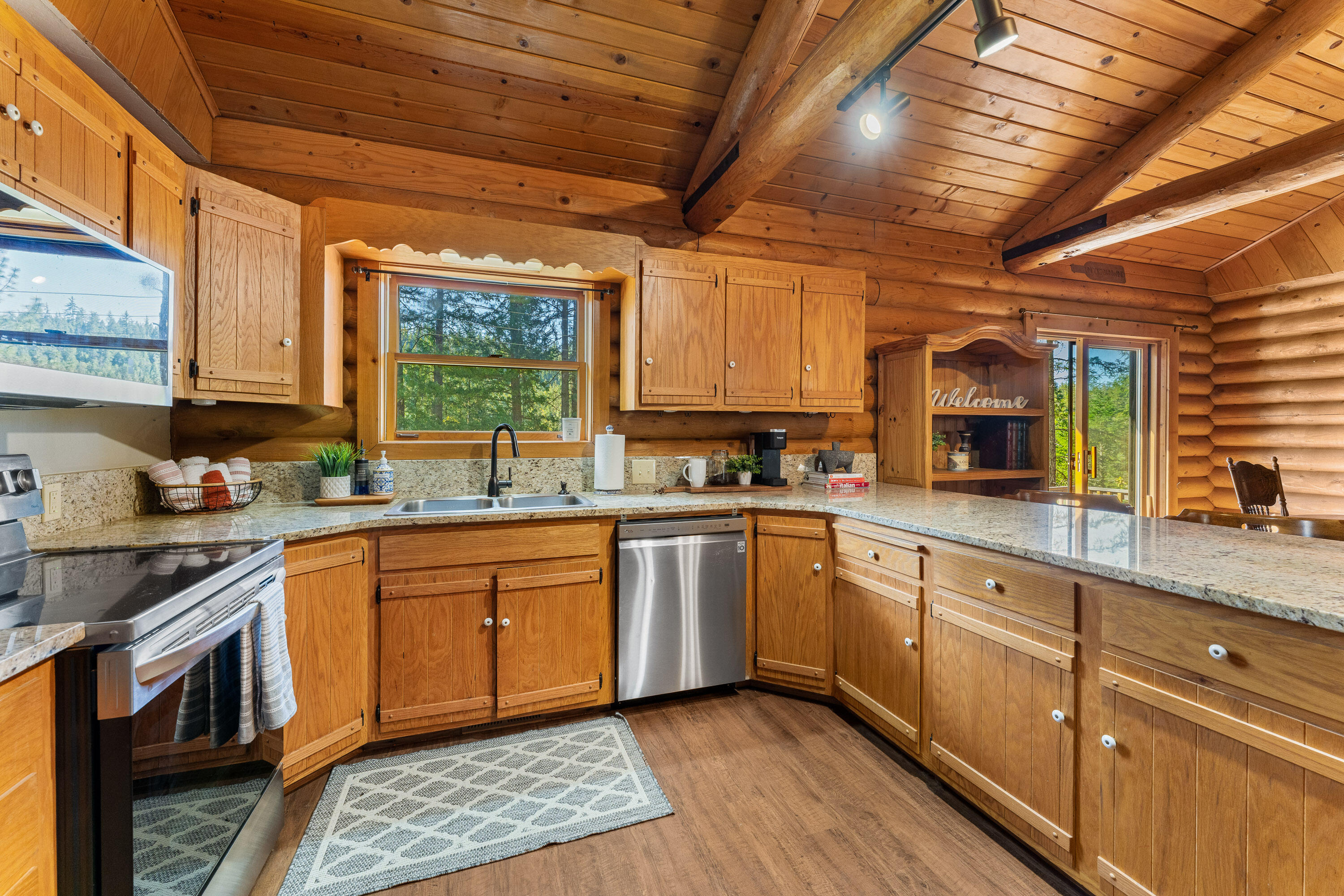 1201 Reeves Creek Road Selma, OR 97538 - Photo 12 of 38 a kitchen with stainless steel appliances granite countertop wooden cabinets sink and stove top oven