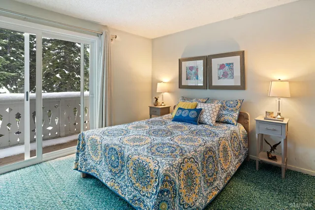 a large bed sitting in a bedroom next to a window