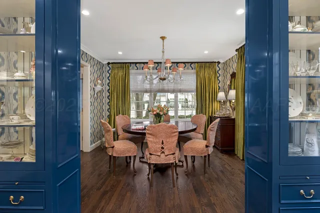 a dining room with furniture a chandelier and wooden floor