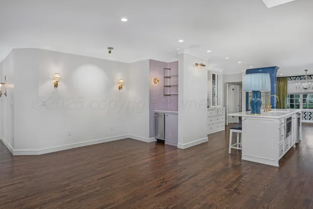 a kitchen with a sink a stove a refrigerator and white cabinets