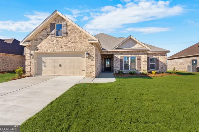 a front view of a house with a garden and yard