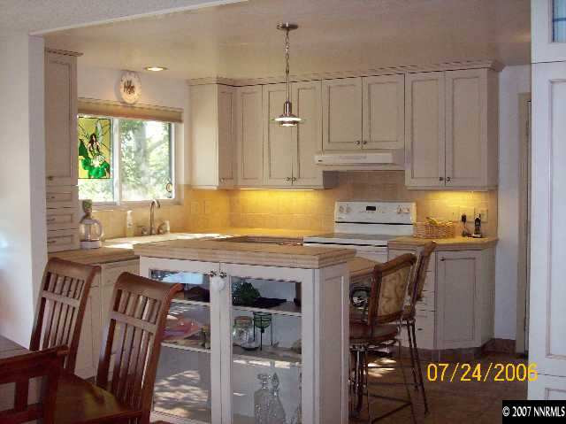 14475 Huron Trail Reno, NV 89521 - Photo 4 of 9 a kitchen with a wooden cabinets a sink a stove and a window