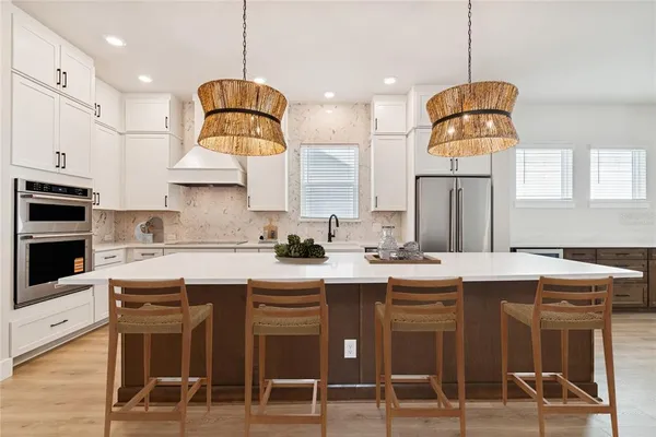 a kitchen with kitchen island white cabinets and refrigerator