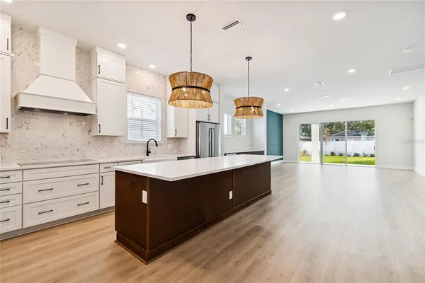 a kitchen with kitchen island granite countertop stove top oven and cabinets
