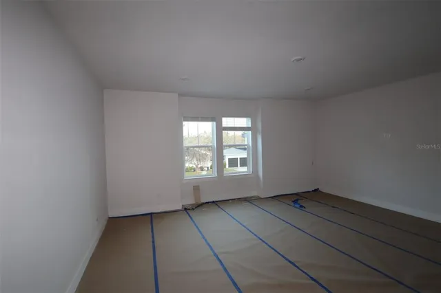 an empty room with wooden floor and glass door
