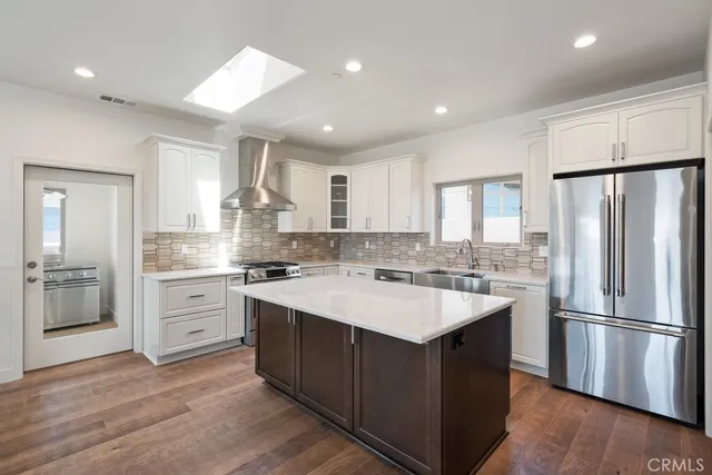 a kitchen with stainless steel appliances granite countertop a refrigerator and a sink