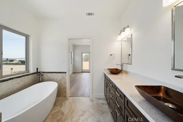 an empty room with ceiling fan and windows