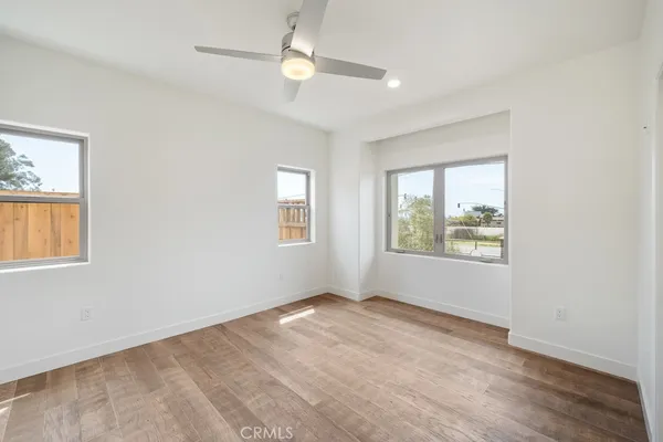 a view of an empty room with window and wooden floor